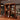 Wooden bar shelf with various bottles of alcohol and glasses on a wooden counter.