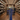 Wine cellar with shelves stocked with bottles and a person inspecting them.