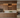 Modern kitchen with wooden cabinets and wine bottles.