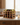 Wooden wine rack with bottles on a kitchen counter with a candle
