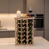 Wooden wine rack with bottles on a kitchen counter, accompanied by a glass of red wine and a candle.