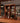 Wooden bar shelf with various bottles of alcohol and glasses on a wooden counter.