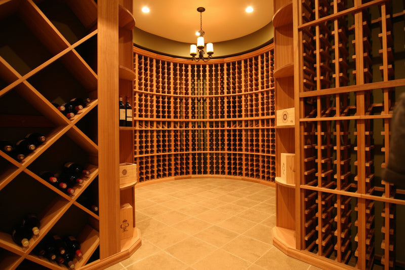 Wine cellar with wooden shelves filled with wine bottles.