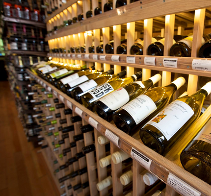 Wine bottles on wooden shelves in a wine cellar