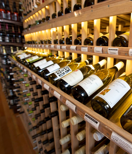Wine bottles on wooden shelves in a wine cellar