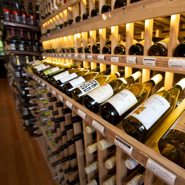 Wine bottles on wooden shelves in a wine cellar
