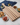 Wooden cutting board with various snacks on a marble surface