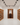 Wine cellar with wooden shelves and wine racks on white walls and floor.