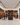 Wine store interior with wooden shelves and wine bottles, people interacting.