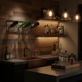Dark kitchen with wooden walls, hanging bottles, and a bar setup.