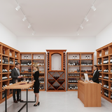 Modern wine store interior with wooden shelves and staff interacting.