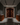 Wine cellar with wooden wine racks and bottles against a stone wall.