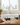 Wine bottles on a rack in a kitchen setting with a window and sink in the background.