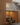 Wooden kitchen cabinet with a pull-out wine rack containing bottles.