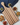 Wooden serving board with striped pattern on a white surface with snacks.