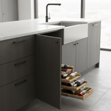 Modern kitchen with open drawer revealing bottles, set against a neutral color palette.