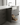 Modern kitchen with open drawer revealing bottles, set against a neutral color palette.