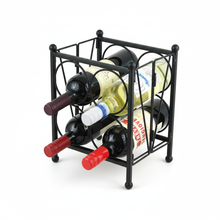 Black metal wine rack holding four bottles on a white background