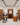 Wine cellar with wooden shelves and people interacting with wine bottles.