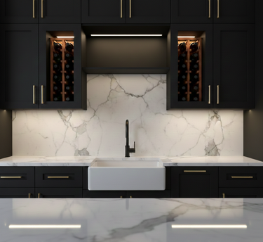 Modern kitchen with black cabinets, marble backsplash, and white countertops.