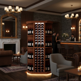 Wine cellar with shelves filled with bottles in a dimly lit room with chandeliers and a fireplace.