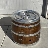 Wooden barrel with metal bands and cap on a concrete surface
