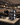 Wine store interior with a staff member using a tablet and wine rack on a counter.