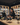 Woman working at a wine store counter with shelves of wine bottles in the background.