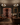 Luxury living room with wine rack, chandeliers, and people in formal attire.
