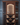 Wooden wine rack with bottles and glasses against a gray tiled wall.