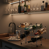 Wine bottles on a rack with glasses on a bar counter