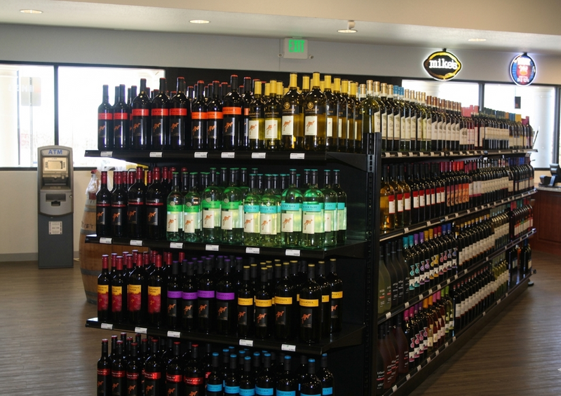 Alcohol metal commercial shelves with various bottles in a store setting