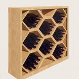 Wooden wine rack with honeycomb design holding bottles on a light beige background