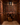 Wine cellar with wooden racks filled with wine bottles and a basket on the floor.