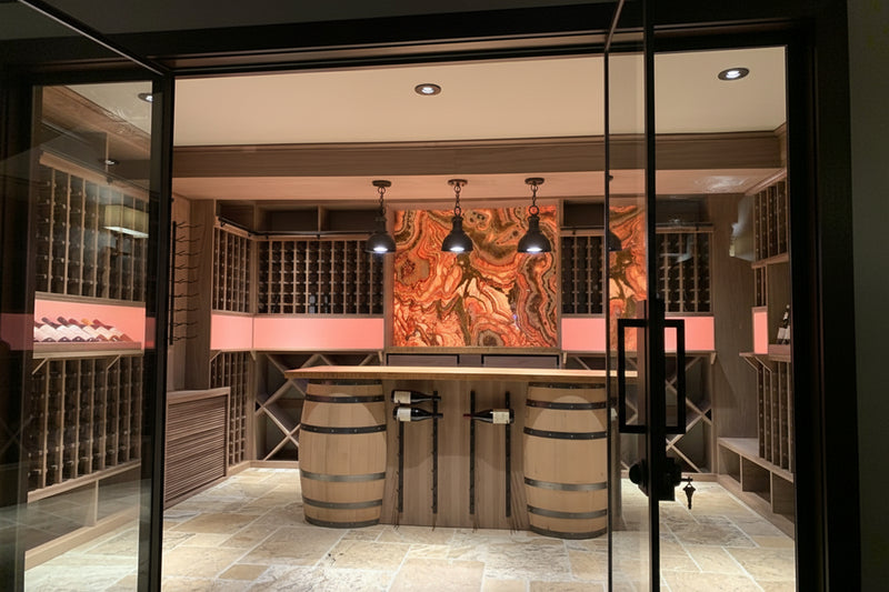Modern wine cellar with wooden barrels and decorative wall art.