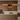 Modern kitchen with wooden cabinets and wine bottles.
