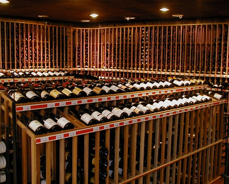 retail wine racks with rows of wine bottles on wooden racks.