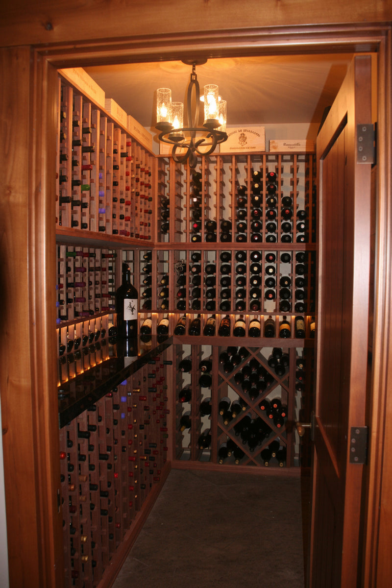 Wooden wine cellar with shelves filled with wine bottles.