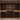 Wooden wine rack filled with wine bottles against a neutral wall.