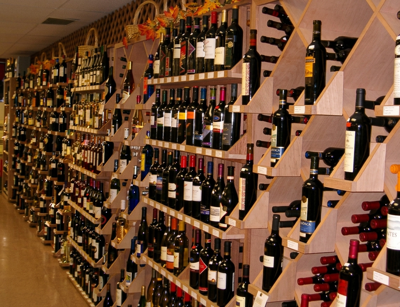 Wine bottles arranged on wooden retail shelves in a store setting