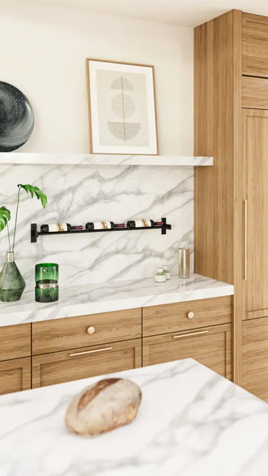 Modern kitchen with wooden cabinets, marble backsplash, and a loaf of bread on a white surface.