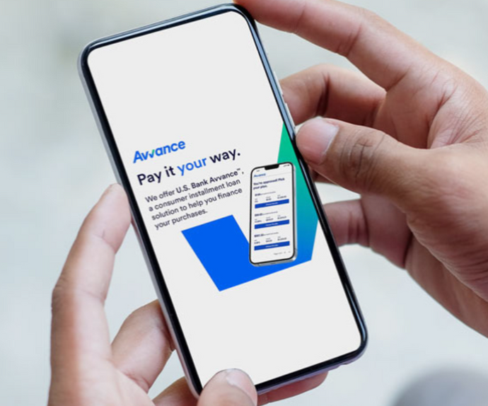 Person holding a smartphone displaying an Avance financial app on a light background