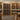 Wine cellar with wooden shelves and wine bottles in a well-lit room.