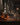 Bar setting with bottles and glasses on a counter, blurred background of people.