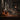 Bar setting with bottles and glasses on a counter, blurred background of people.
