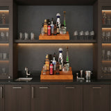 Modern kitchen with dark cabinets, black countertop, and various bottles and glasses.