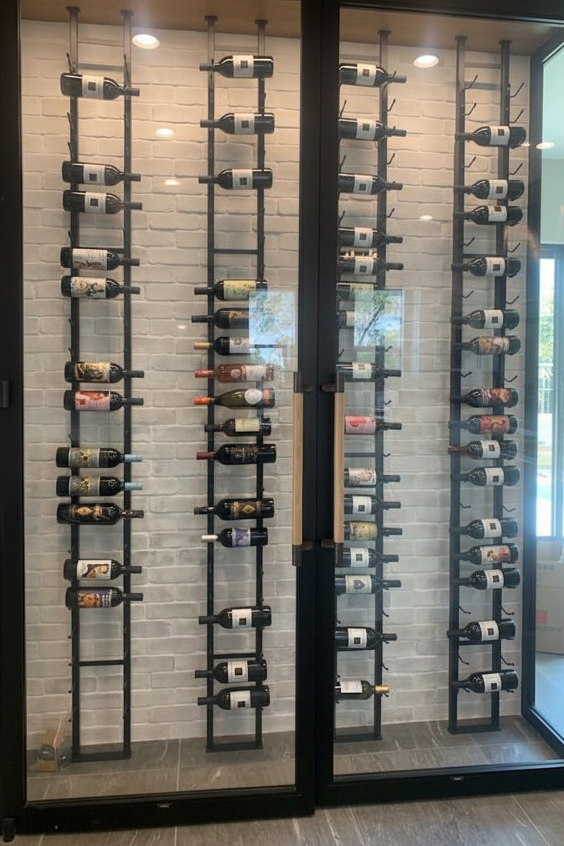 Wine bottles arranged vertically on metal racks in a modern interior setting.