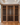 Wooden wine rack filled with bottles in a room with a fireplace and television.