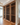 Wooden wine rack filled with bottles in a room with a fireplace and television.
