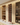 Wine rack in a wooden cabinet with wine bottles and glasses.